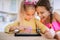 Two little sisters play on a Tablet PC