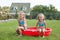 Two little sisters sitting in their yard in small