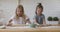 Two little smiling children sisters involved in funny cooking activity.