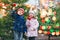 Two little smiling kids, preschool boy and girl eat sweet sugared apple on German Christmas market. Happy siblings