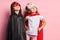 Two little superheroes looking up isolated over pink background