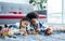 Two little sweet diverse Caucasian and African girl and boy laying down on the floor, playing toys together with happiness in