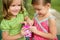 Two little twin sisters playing with pink box