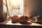 two loaves of bread sitting on a table next to a cup of coffee and a potted plant on a window sill with a sunny window behind it