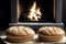 Two loaves on a table in front of a fireplace.