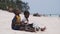 Two Local African Boys Sit on Beach and Play Improvised Bottle Drums, Zanzibar