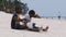 Two Local African Boys Sit on Beach and Play Improvised Bottle Drums, Zanzibar