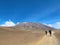 Two local people walking on an unpaved road near to Mount Kilimanjaro in bright sunlight, Tanzania