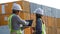 Two logistic staff discussing while checking and control loading containers box from cargo.