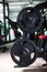 Two long barbells on a stand. Barbell holder on a blurred gym background. Heavy, huge black dumbbells. Sport equipment.