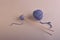 Two long wooden needles in a small ball of beautiful gray-blue thread next to a large ball of thread, on a harmonious soft beige