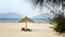 Two lounge chairs thatched umbrella on beach