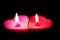 Two love heart candles on a black background