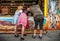 Two lovely girls, one man playing shooting games and having fun at German funfair Oktoberfest. Wearing traditional