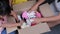 Two lovely sisters with her mother putting her old dolls in a donation box at home. Charitable stuffed dolls donation for kids. Do