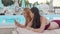 Two lovely women using smart phone while resting by the swimming pool