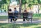 Two lovers couples sitting on different ends of one bench