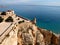 Two lovers embrace overlooking the sea from a castle in spain