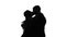 Two lovers embracing and kissing. Silhouette. White
