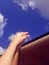 Two lovers holding hands in car ride with sky and clouds backround