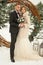 Two lovers, a man and a woman, a wedding in winter. bride and groom love. against the backdrop of decor and trees, snow. holding a