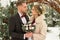 Two lovers, a man and a woman, a wedding in winter. bride and groom love. against the backdrop of decor and trees, snow. holding a