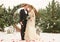 Two lovers, a man and a woman, a wedding in winter. bride and groom love. against the backdrop of decor and trees, snow. holding a