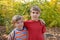 Two loving brothers are hugging in the park on a background of autumn leaves