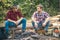 Two lumberjack men making picnic. Enjoying camping holiday in countryside. Happy young male friends having picnic