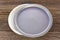 Two luncheon plastic round food plates on wooden background