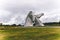 Two majestic horse statues standing tall against a cloudy sky in Kelpher.