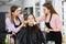 Two makeup artists applying decorative cosmetics to young female client