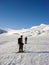 Two male backcountry ski mountaineers head towards a high alpine peak over a long glacier between Saas Fee and Zermatt