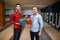 Two male bowlers poses on lane with balls on hands