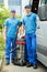 Two Male Cleaners With Vacuum Cleaner