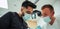 Two male dentists wearing surgical masks operating on patient