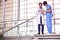 Two Male Doctors Having Informal Meeting In Modern Hospital Looking At Digital Tablet