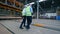 Two male engineers are walking along the industrial factory floor