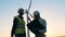 Two male experts are having a discussion in front of windmill. Clean, eco-friendly energy concept.