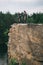 two male extreme cyclists in protective helmets jumping on mountain bicycles on rocky cliff