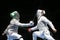 Two male fencing athletes fight