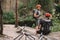 two male friends with backpacks and bicycles resting near river