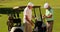 Two male friends chatting on the golf course by their kart