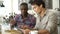 Two Male Friends In Coffee Shop Looking At Digital Tablet