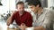 Two Male Friends In Coffee Shop Looking At Digital Tablet