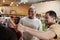 Two male friends look at clothes in a clothes shop, close up