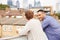 Two Male Friends Relaxing On Rooftop Garden Drinking Coffee