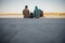 Two male friends siting with guitar near river