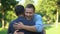 Two male friends suddenly meeting and hugging outdoors, pleasure emotions