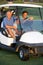 Two Male Golfers Riding In Golf Buggy